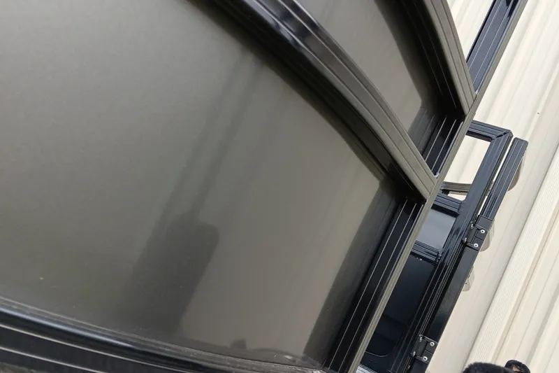 Slide: The Image of Close-up of a 2026 Ranger 220F boat's sleek black exterior and window frames. - 9