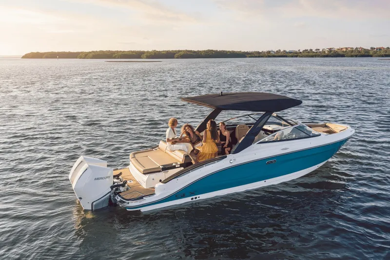 Slide: The Image of Three people relax on a Sea Ray SLX 280 Outboard on calm water at sunset. - 4