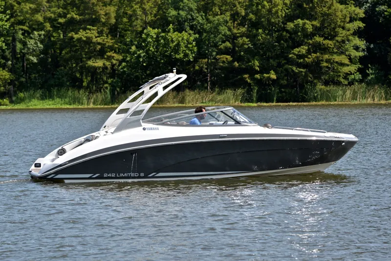 Slide: The Image of 2015 Yamaha Boats 242 Limited S cruising on a serene lake with lush greenery. - 28