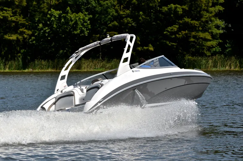 Slide: The Image of 2015 Yamaha Boats 242 Limited S cruising on a lake with lush greenery. - 5