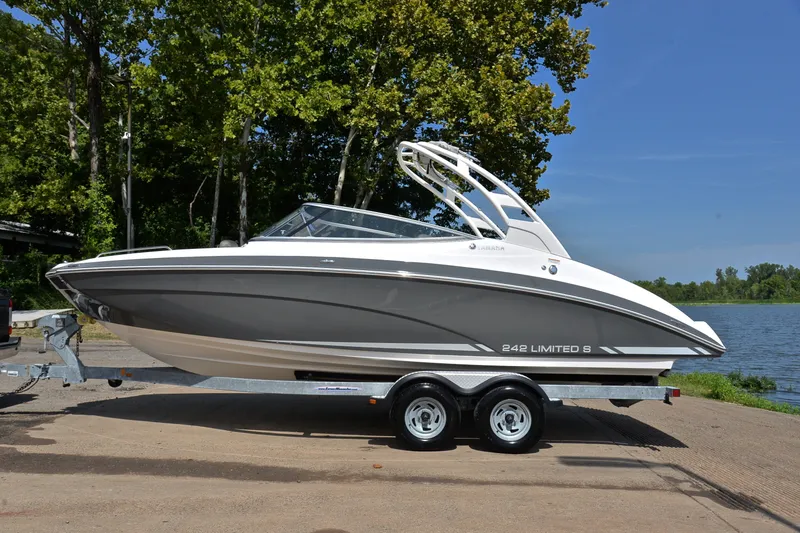 Slide: The Image of 2015 Yamaha Boats 242 Limited S on trailer by a lake, surrounded by trees. - 10