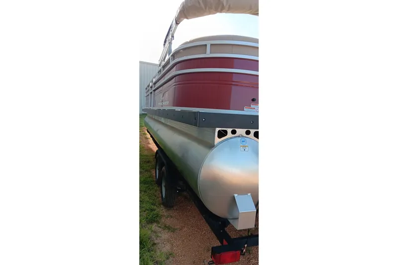 Slide: The Image of 2025 Sun Tracker Party Barge 24 DLX pontoon boat on trailer, side view. - 3