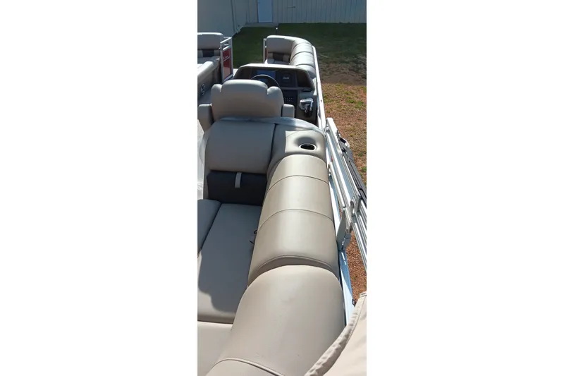 Slide: The Image of 2025 Sun Tracker Party Barge 24 DLX interior with beige seating and cup holders. - 7