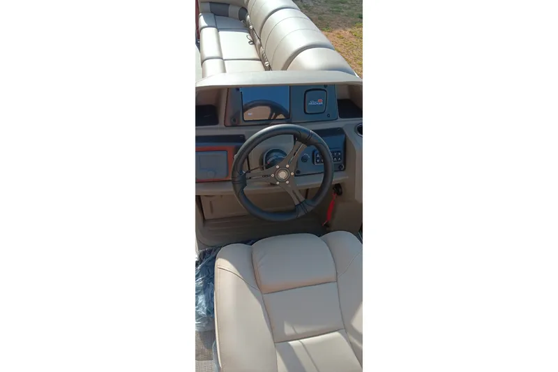 Slide: The Image of 2025 Sun Tracker Party Barge 24 DLX steering console with comfortable seating. - 10