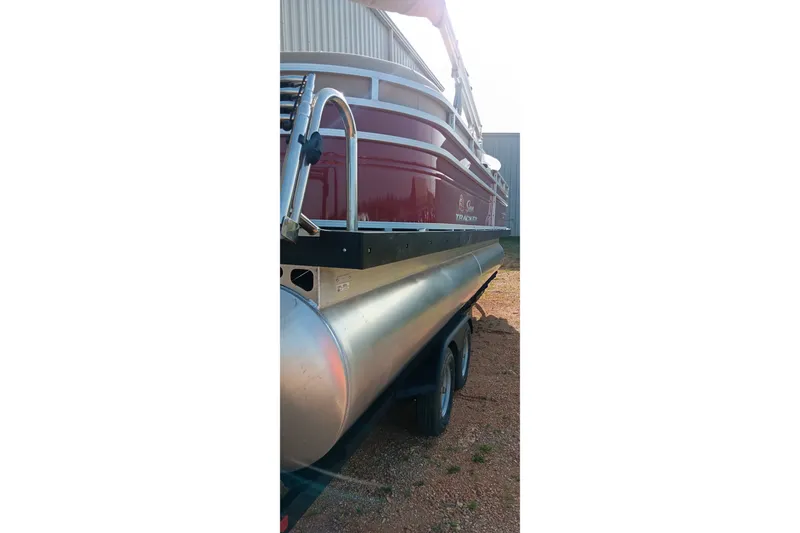 Slide: The Image of 2025 Sun Tracker Party Barge 24 DLX pontoon boat on trailer, side view. - 4