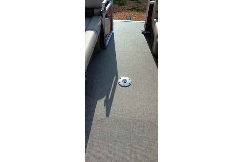 Slide: The Image of 2025 Sun Tracker Party Barge 24 DLX interior flooring with seating and open door. - 16