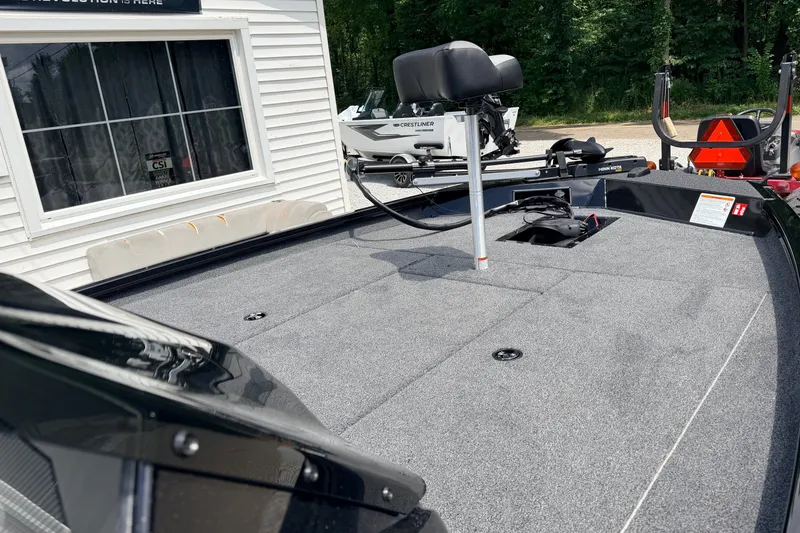 Slide: The Image of 2027 Crestliner XF 189 boat deck with seating and equipment, parked near a building. - 6