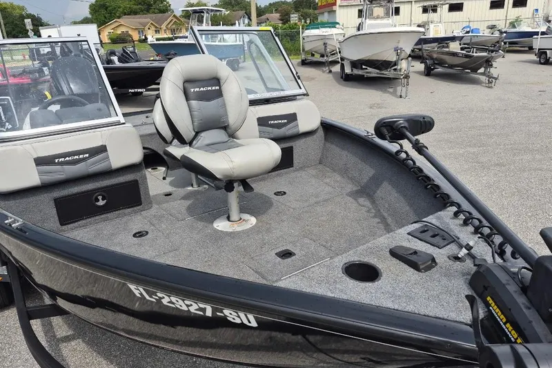Slide: The Image of 2018 Tracker Pro Guide V-175 Combo boat with seating and trolling motor in a marina. - 10