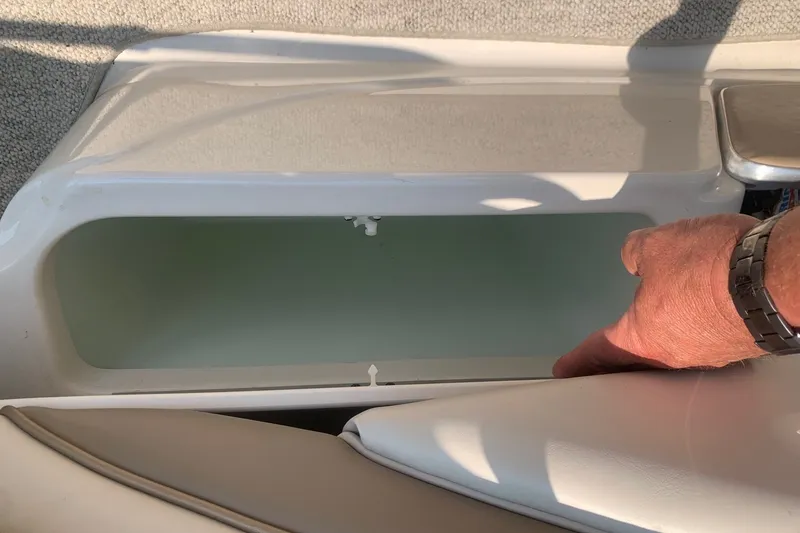 Slide: The Image of Boat storage compartment in a 2000 Maxum 2300 SC, with hand for scale. - 23
