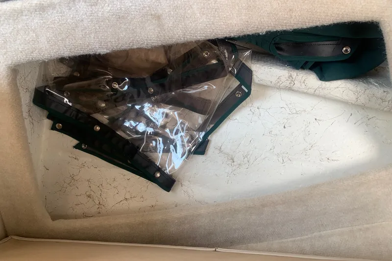 Slide: The Image of Storage compartment in a 2000 Maxum 2300 SC boat with clear plastic covers. - 26
