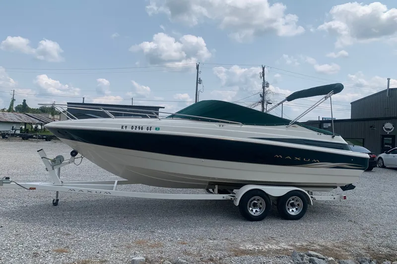 Slide: The Image of 2000 Maxum 2300 SC boat on trailer under cloudy sky. - 1
