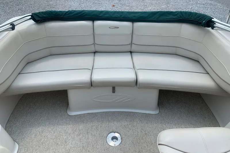 Slide: The Image of 2000 Maxum 2300 SC boat interior with beige seating and carpeted flooring. - 15