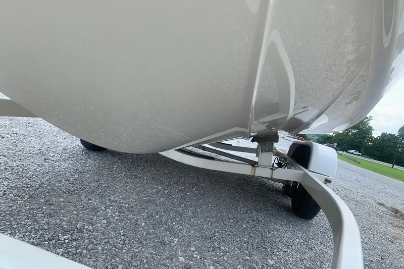 Slide: The Image of 2000 Maxum 2300 SC boat on trailer, viewed from below on gravel surface. - 4