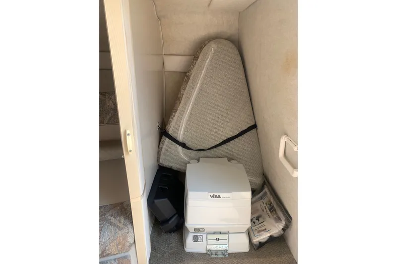 Slide: The Image of Interior storage of 2000 Maxum 2300 SC boat with portable toilet and cushions. - 19