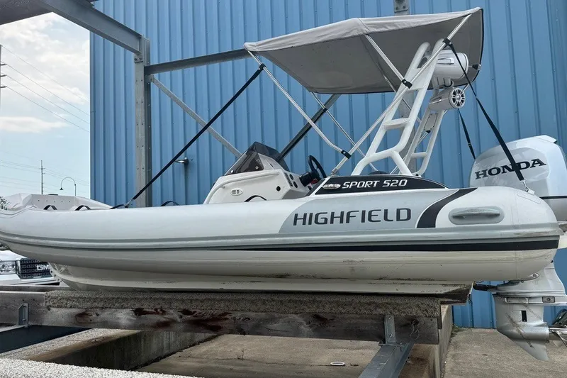 Slide: The Image of 2021 Highfield Sport 520 boat with Honda engine, displayed on a stand. - 15