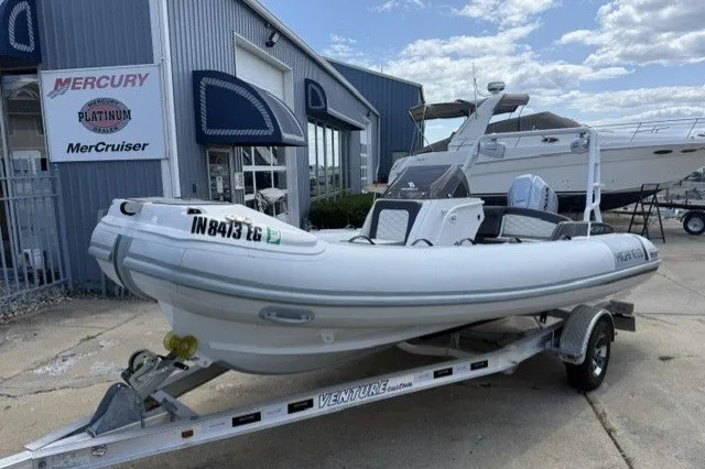 The Image of 2021 Highfield Sport 520 boat on trailer outside marine dealership. - 0