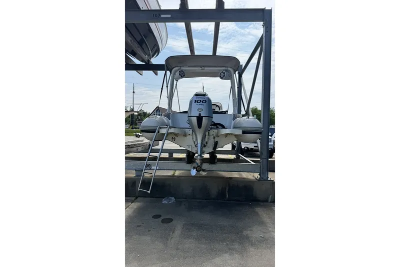 Slide: The Image of 2021 Highfield Sport 520 boat on a rack, featuring a 100 HP engine. - 13