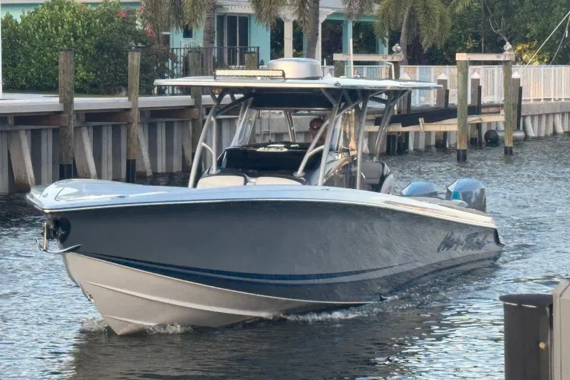 Slide: The Image of 2024 Nor-Tech 340 Sport boat cruising on a calm waterway near a dock. - 8