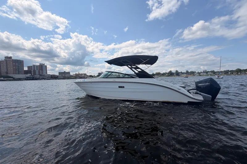 The Image of 2025 Sea Ray SDX 250 Outboard boat on water, city skyline in background. - 0