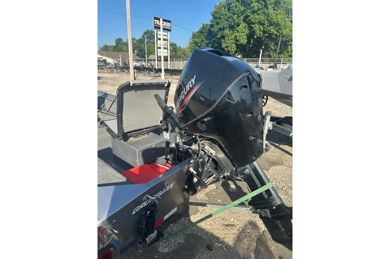 Slide: The Image of Outboard motor on a 1991 Grumman Rouge 150 T boat, parked outdoors. - 18