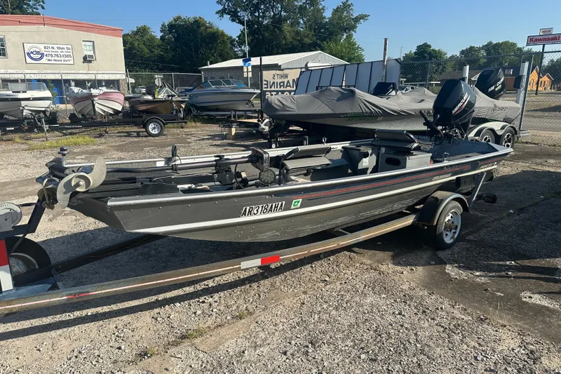 Slide: The Image of 1991 Grumman Rouge 150 T boat on trailer in outdoor lot. - 1