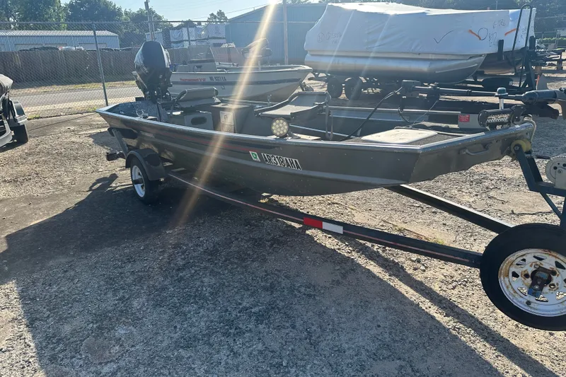Slide: The Image of 1991 Grumman Rouge 150 T boat on trailer in outdoor storage area. - 4