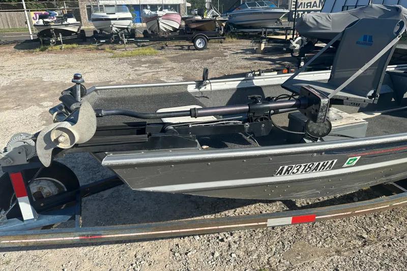 Slide: The Image of 1991 Grumman Rouge 150 T boat on trailer, with visible motor and seating. - 15