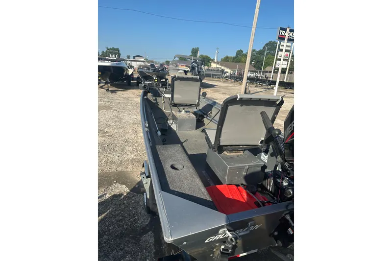 Slide: The Image of 1991 Grumman Rouge 150 T boat with seating, parked outdoors on a sunny day. - 17
