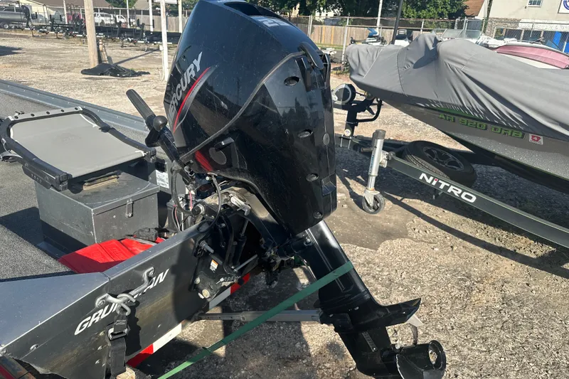 Slide: The Image of Outboard motor on a 1991 Grumman Rouge 150 T boat, parked on a trailer. - 10