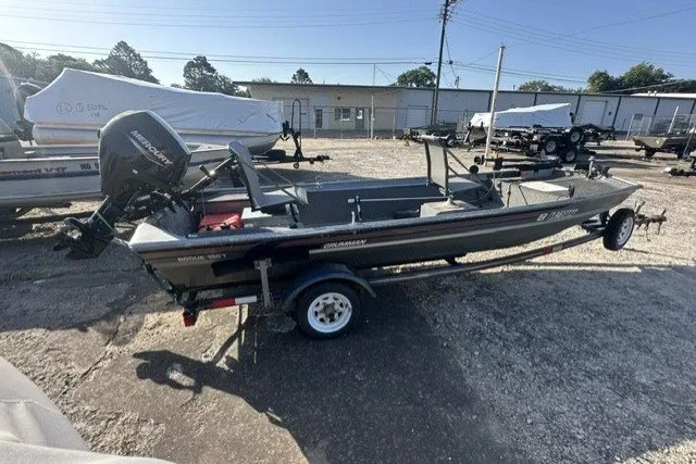 The Image of 1991 Grumman Rouge 150 T boat on trailer in outdoor storage area. - 0