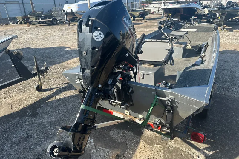 Slide: The Image of 1991 Grumman Rouge 150 T boat with Mercury outboard motor in a boatyard. - 9