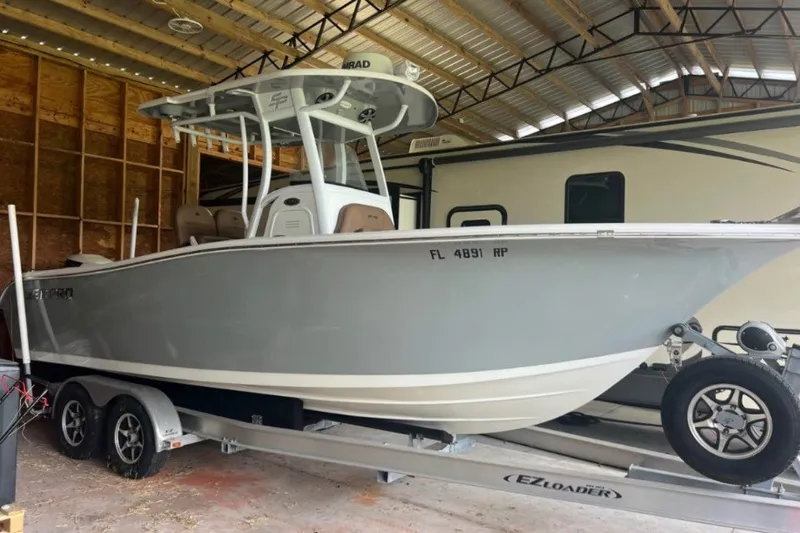 The Image of 2018 Sea Pro 239 Center Console boat on trailer in covered storage. - 0