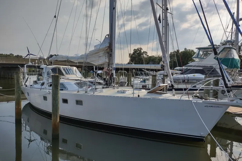 Slide: The Image of Sailboat Garcia Passoa 47, 2005 model, docked at a marina under a cloudy sky. - 38
