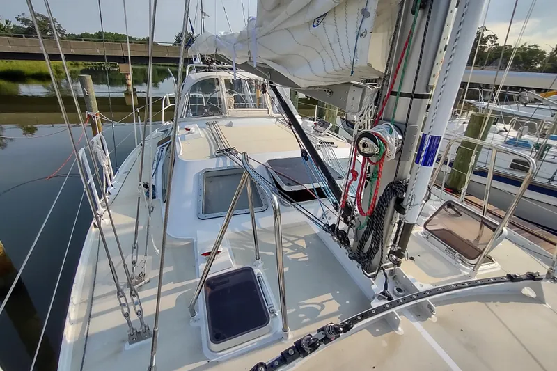 Slide: The Image of Deck view of 2005 Garcia Passoa 47 sailboat, showcasing rigging and hatches at a marina. - 56