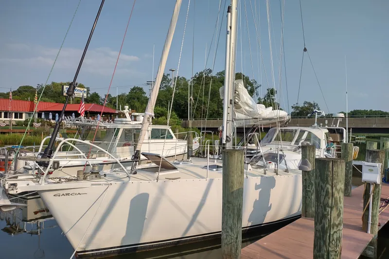 Slide: The Image of Sailboat Garcia Passoa 47, 2005 model, docked at a marina with clear skies. - 39