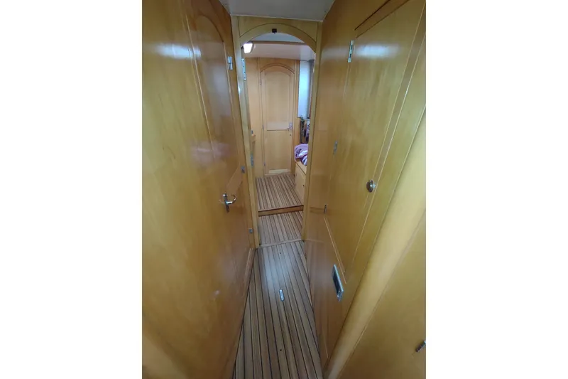 Slide: The Image of Narrow wooden hallway inside 2005 Garcia Passoa 47 yacht, featuring sleek cabinetry and striped flooring. - 25