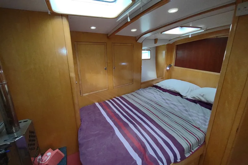 Slide: The Image of Cozy cabin interior of 2005 Garcia Passoa 47 yacht with striped bedding. - 33