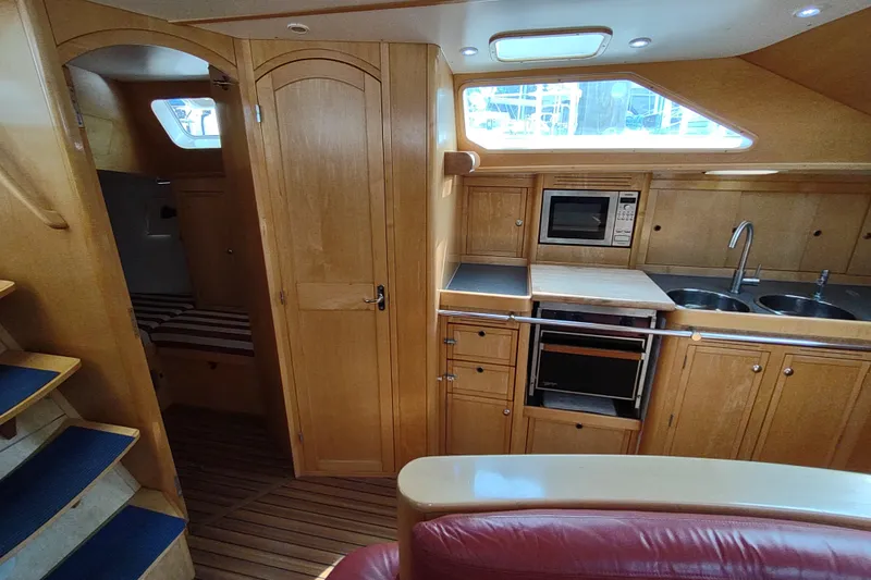 Slide: The Image of Interior of 2005 Garcia Passoa 47 yacht with wooden cabinetry and modern kitchen amenities. - 15