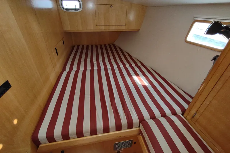 Slide: The Image of Cozy cabin interior of 2005 Garcia Passoa 47 with striped bedding. - 23