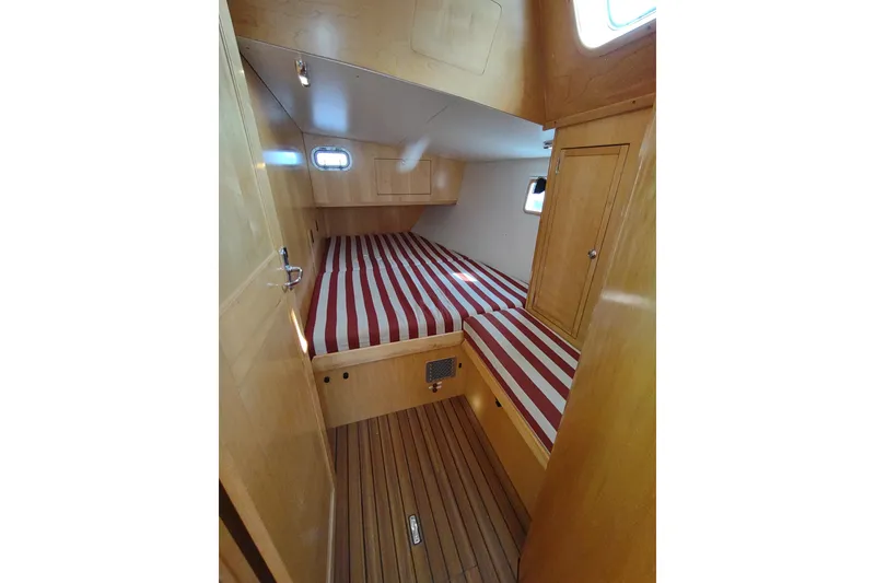 Slide: The Image of Cozy cabin interior of 2005 Garcia Passoa 47 yacht with striped bedding and wooden finish. - 21