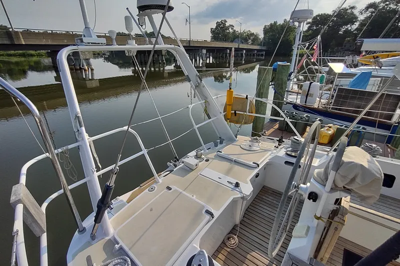 Slide: The Image of Deck view of 2005 Garcia Passoa 47 sailboat docked by a bridge. - 59