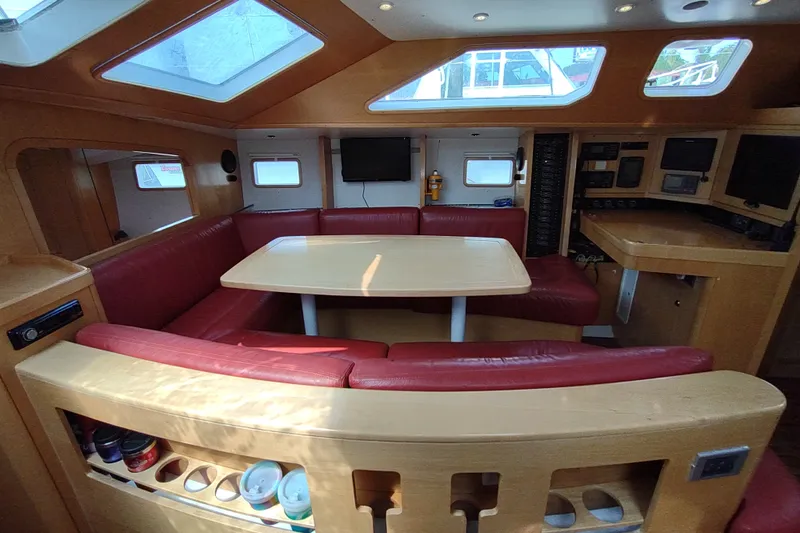 Slide: The Image of Interior of 2005 Garcia Passoa 47 yacht with red seating and wooden table. - 13
