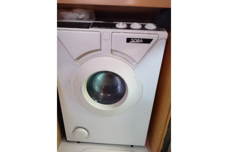 Slide: The Image of Compact white washing machine in a wooden cabinet, featuring a front-loading design. - 71