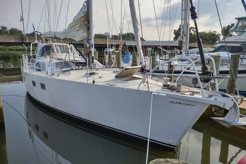Slide: The Image of Sailboat Garcia Passoa 47, 2005 model, docked in a marina with clear skies. - 37