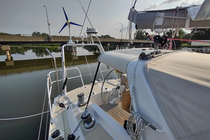 Slide: The Image of Sailboat Garcia Passoa 47 (2005) docked near a bridge, featuring a wind turbine. - 58