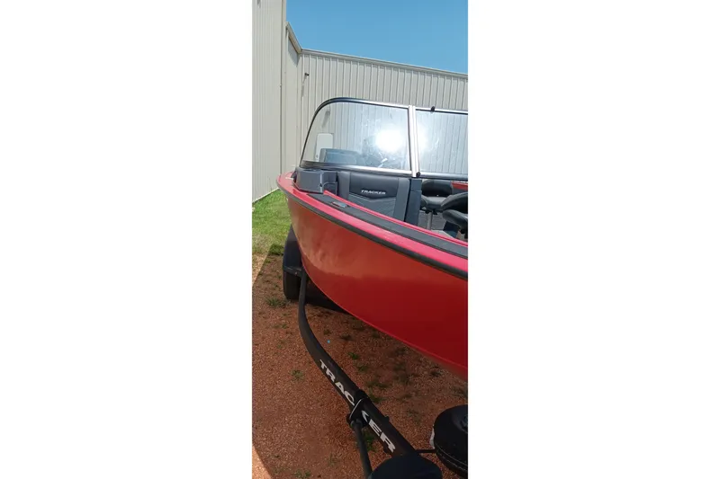 Slide: The Image of Red 2026 Tracker Targa V-18 Combo boat parked outdoors near a building. - 15