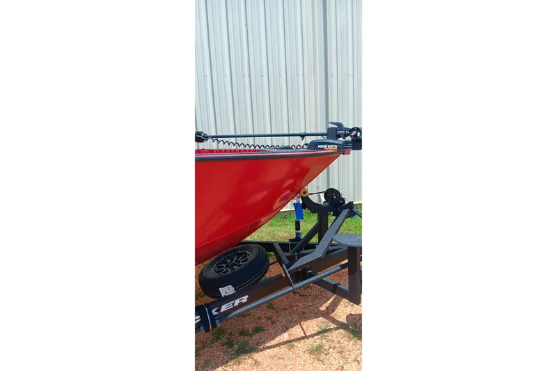 Slide: The Image of Red 2026 Tracker Targa V-18 Combo boat on trailer, parked outdoors. - 6
