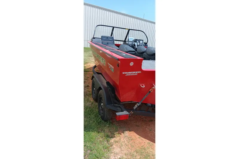 Slide: The Image of Red 2026 Tracker Targa V-18 Combo boat on trailer, parked outdoors. - 3