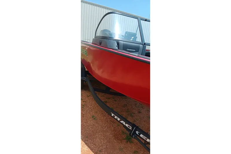 Slide: The Image of Red 2026 Tracker Targa V-18 Combo boat on trailer, parked outdoors. - 16
