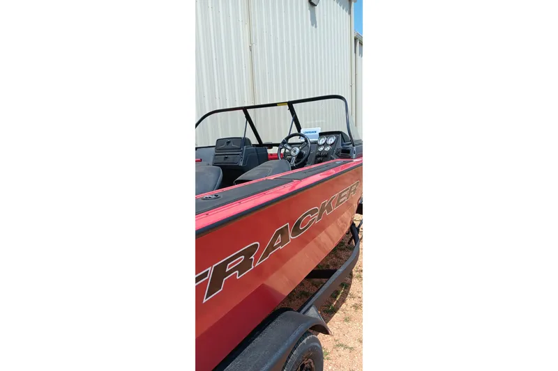 Slide: The Image of 2026 Tracker Targa V-18 Combo boat, red exterior, parked outdoors near a building. - 5